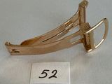 a close up of a gold hair clip on a white surface
