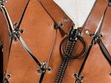 a close up of a leather vest with a zipper on it