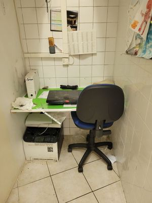 a desk with a chair and a printer in a small room
