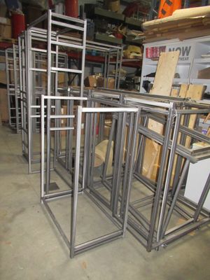 many metal frames stacked on top of each other in a warehouse
