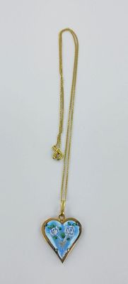 une chaîne en or à laquelle est suspendu un pendentif en forme de cœur bleu