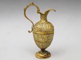 an ornate gold vase with a handle on a white background