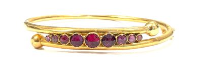 an image of a close up of a gold bracelet with red stones
