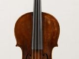 an old violin sitting on top of a white table