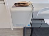 a printer sitting on top of a desk next to a paper towel dispenser