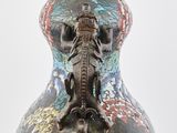 a vase with a dragon on it sitting on a table