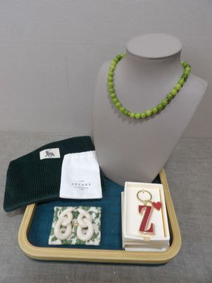 a necklace, bracelet, and other items that are on a tray