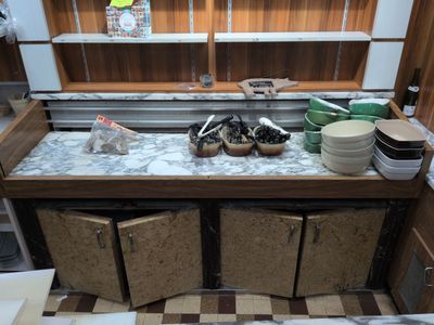 a kitchen counter with many dishes and bowls on it