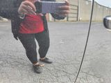 a woman taking a picture of herself in the reflection of a car