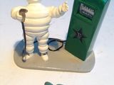 figurine représentant un homme avec une pompe à essence, à côté d'une pompe à essence verte