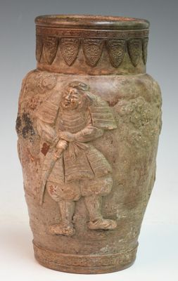 a vase with a man on it sitting on a table