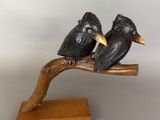 two birds that are sitting on a tree branch