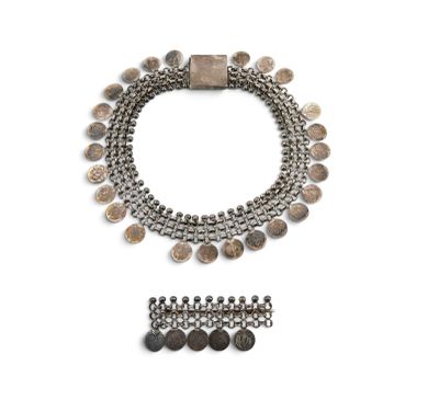 a close up of a necklace and bracelet on a white surface
