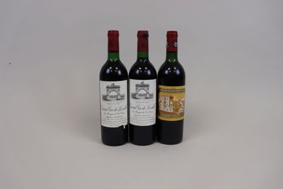 trois bouteilles de vin rouge sont posées sur une surface blanche
