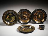 quatre assiettes décorées de noir et d'or et un petit bol