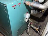a green gas heater sitting in a dirty room