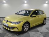 Une Volkswagen Golf jaune est garée sur un sol à damier.