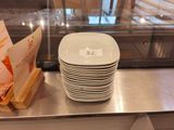 a stack of plates sitting on a counter next to a glass case