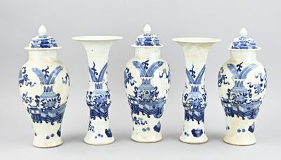 quatre vases bleus et blancs sont alignés sur un fond gris