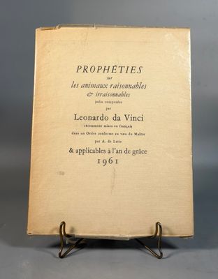 an old book sitting on top of a metal stand on a gray surface