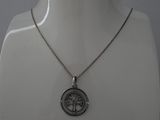 un torse de mannequin blanc portant un collier en argent orné d'un arbre de vie