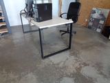 un bureau avec un ordinateur et une chaise dans la chambre