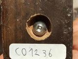 a person holding a piece of wood with a metal ball in it
