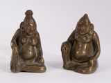 pair of bronze figurines of a seated man and a seated woman