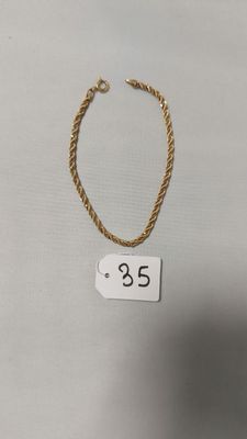 un collier en or sur lequel figure un petit chiffre