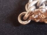 a close up of a silver and gold necklace on a black cloth