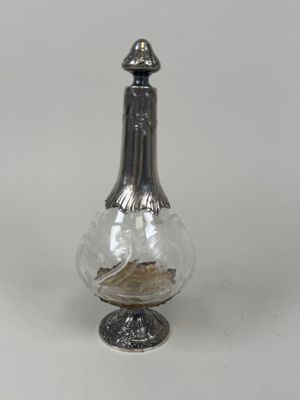 a small glass vase with a bird inside of it