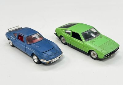 deux voitures jouets assises l'une à côté de l'autre sur une surface blanche