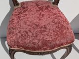 a chair with a red velvet seat and a wooden frame