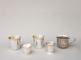 Plusieurs coupes en argent sont alignées sur une table