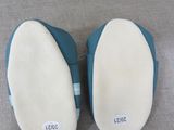 pair of blue slippers with white soles sitting on a couch