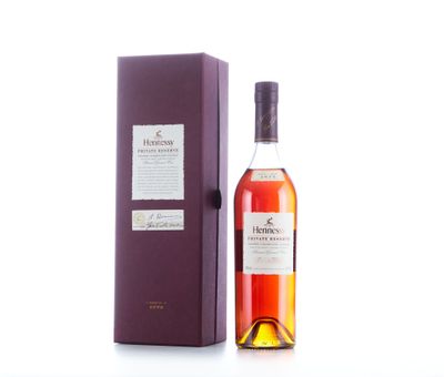une bouteille de whisky dans un coffret violet posée sur une surface blanche