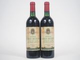 deux bouteilles de vin rouge posées l'une à côté de l'autre sur une surface blanche