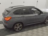 a picture of a grey bmw suv parked in a garage