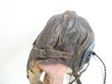 une main tenant un gant de baseball sur lequel sont posés des écouteurs