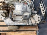a small air compressor sitting on a pallet next to a pile of wires