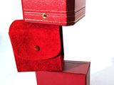 une boîte rouge sur laquelle est posé un étui rouge