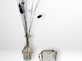 two vases with flowers in them on a white table