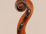 a close up of the back of a violin with a fiddle in the foreground