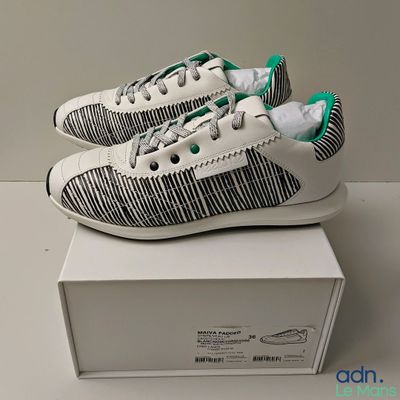 they are two pairs of white and green sneakers on a white box
