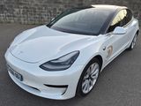 La Tesla Model 3 blanche est garée sur un parking