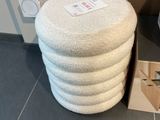 un tabouret blanc posé à côté des toilettes dans une salle de bains