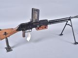 an old machine gun on a stand with a magazine on it