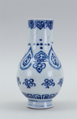 un vase bleu et blanc posé sur une surface blanche