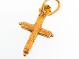 une image représentant un pendentif en forme de croix en or sur fond blanc