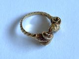 a gold ring with a snake on it on a white surface